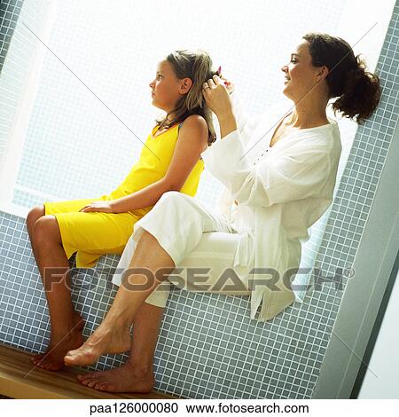 Mother fixing daughter's hair, side view View Large Photo Image Stock Image - Mother fixing daughter's hair, side view. Fotosearch