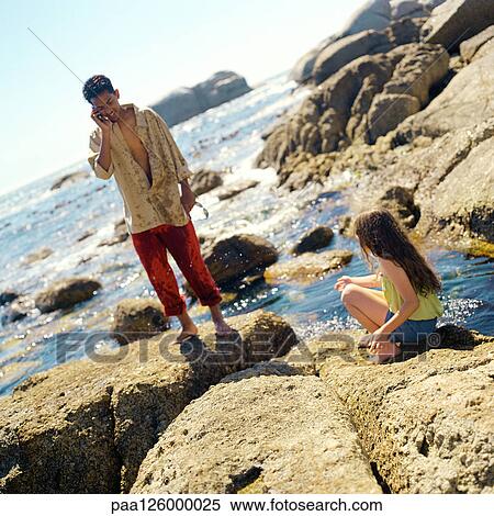 Teenager using cell phone, child sitting on rock View Large Photo Image Stock Photography - Teenager using cell phone, child sitting on rock. Fotosearch