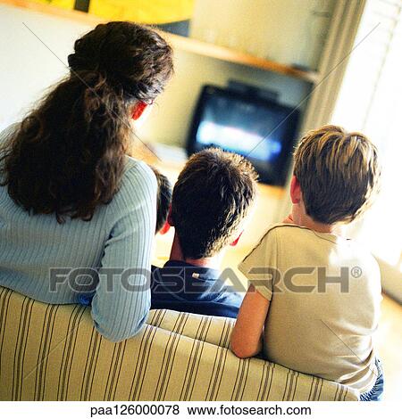 Woman and children sitting on sofa watching tv, rear view View Large Photo Image Stock Photo - Woman and children sitting on sofa watching tv, rear view. Fotosearch
