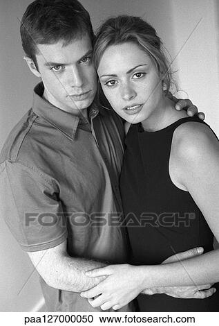 Couple standing in each others arms, portrait, b&w View Large Photo Image Stock Image - Couple standing in each others arms, portrait, b&w. Fotosearch