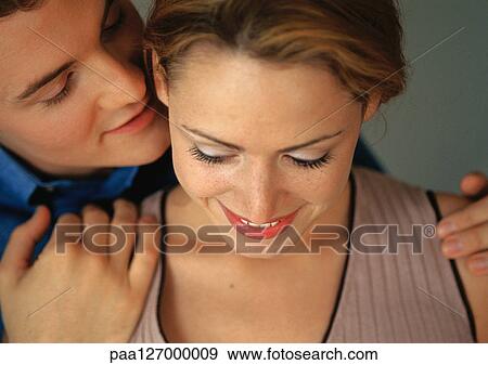 Stock Photo - Man holding woman's shoulders from behind, close-up. Fotosearch