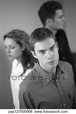 Man standing in front of woman and second man, portrait, b&w View Large Photo Image Stock Photo - Man standing in front of woman and second man, portrait, b&w. Fotosearch