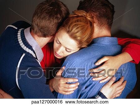 Two men and woman hugging, close-up View Large Photo Image Stock Photograph - Two men and woman hugging, close-up. Fotosearch