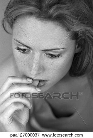 Stock Photo - Woman biting nail, close-up, b&w. Fotosearch