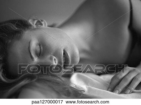Stock Photo - Woman lying down, eyes closed, b&w. Fotosearch