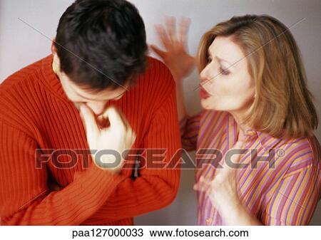 Stock Image - Woman yelling at man, man looking down. Fotosearch
