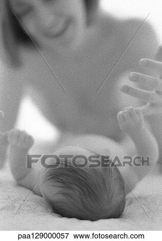 Infant lying down holding mother's finger with hand, b&w View Large Photo Image Stock Photo - Infant lying down holding mother's finger with hand, b&w. Fotosearch