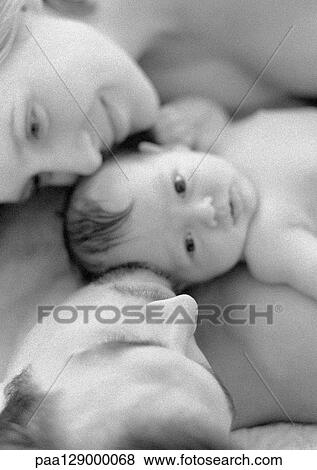 Stock Photo - Mother and father with infant, close-up, high angle view, b&w. Fotosearch