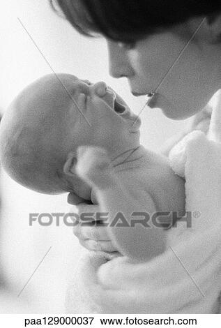 Mother holding crying infant, b&w View Large Photo Image Stock Photo - Mother holding crying infant, b&w. Fotosearch