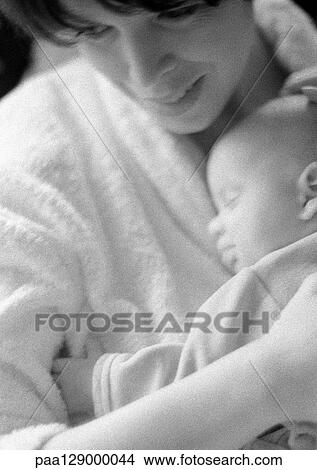 Picture - Mother holding sleeping infant on chest, b&w. Fotosearch