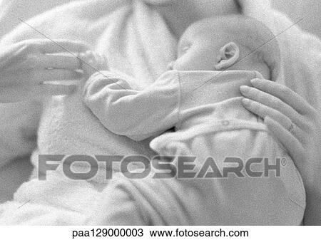 Stock Image - Mother holding sleeping infant on chest, b&w. Fotosearch