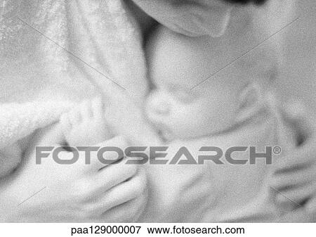 Mother holding sleeping infant on chest, blurred, b&w View Large Photo Image Stock Photo - Mother holding sleeping infant on chest, blurred, b&w. Fotosearch