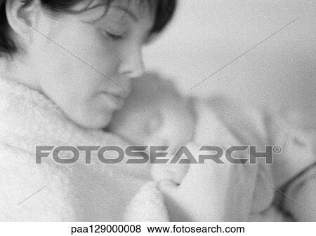 Stock Photo - Mother holding sleeping infant on chest, b&w. Fotosearch