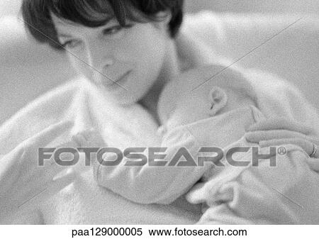 Stock Photography - Mother holding sleeping infant on chest, b&w. Fotosearch