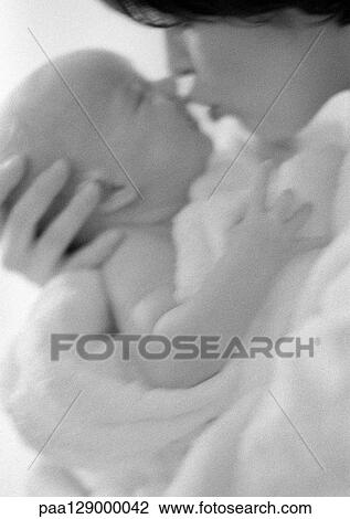 Stock Image - Mother kissing infant, side view, b&w. Fotosearch