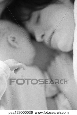 Stock Photograph - Mother sleeping with infant, close-up, b&w. Fotosearch