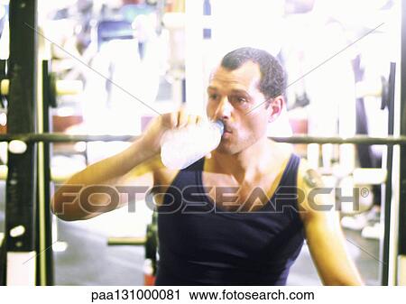 Man drinking water in gym View Large Photo Image Stock Image - Man drinking water in gym. Fotosearch