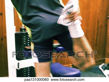 Man standing, stretching next to weight machine View Large Photo Image Stock Image - Man standing, stretching next to weight machine. Fotosearch