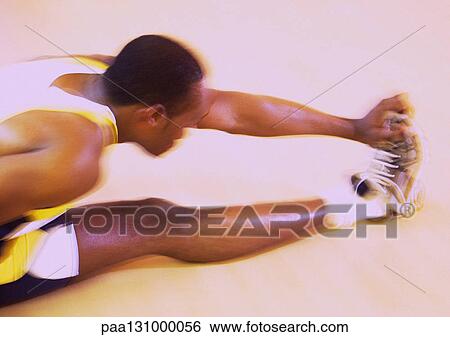Stock Photograph - Man stretching, reaching for toes. Fotosearch