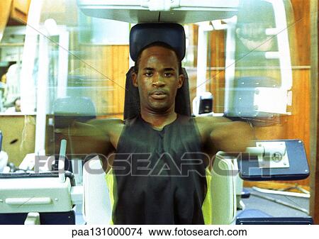 Man using weight machine in gym, blurred motion View Large Photo Image Picture - Man using weight machine in gym, blurred motion. Fotosearch