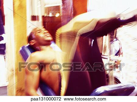 Man using weight machine in gym, blurred motion View Large Photo Image Stock Image - Man using weight machine in gym, blurred motion. Fotosearch