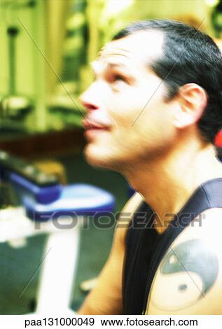 Man with tattoo in gym, side view View Large Photo Image Stock Photo - Man with tattoo in gym, side view. Fotosearch
