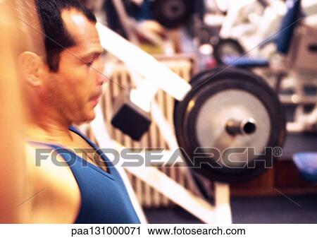 Man working out in gym, side view View Large Photo Image Stock Image - Man working out in gym, side view. Fotosearch