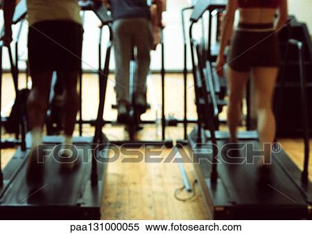 Stock Photography - People using exercise equipment in gym, lower section. Fotosearch