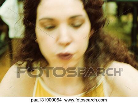 Picture - Woman breathing out, close-up, blurred. Fotosearch