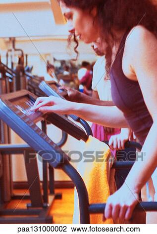 Woman using exercise equipment in gym, side view View Large Photo Image Stock Image - Woman using exercise equipment in gym, side view. Fotosearch