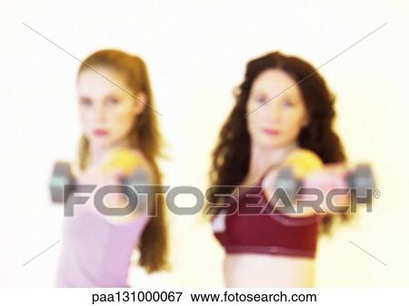Women holding out barbells View Large Photo Image Stock Photo - Women holding out barbells. Fotosearch