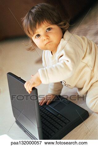 Baby playing with laptop, looking into camera, portrait. View Large Photo Image Stock Photo - Baby playing with laptop, looking into camera, portrait.. Fotosearch