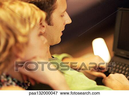 Couple using laptop, close-up. View Large Photo Image Stock Photo - Couple using laptop, close-up.. Fotosearch