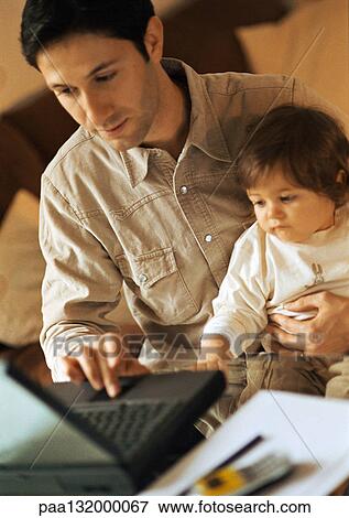 Father and baby, father using laptop, baby sitting on father's lap. View Large Photo Image Stock Photo - Father and baby, father using laptop, baby sitting on father's lap.. Fotosearch