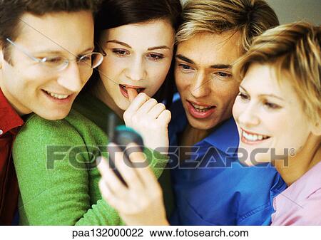 Group of four people using cell phone. View Large Photo Image Stock Image - Group of four people using cell phone. . Fotosearch