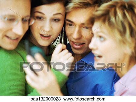 Group of four people using cell phone, blurred, close up. View Large Photo Image Stock Photo - Group of four people using cell phone, blurred, close up.. Fotosearch
