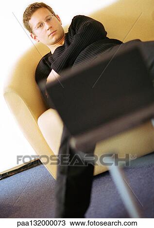 Man sitting, arms crossed, looking at laptop. View Large Photo Image Stock Image - Man sitting, arms crossed, looking at laptop.. Fotosearch