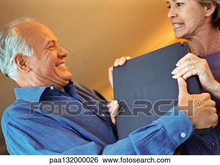 Mature couple fighting over laptop, portrait. View Large Photo Image Stock Photograph - Mature couple fighting over laptop, portrait.. Fotosearch