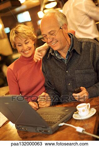 Mature couple in cafÄ using laptop. View Large Photo Image Stock Image - Mature couple in cafÄ using laptop.. Fotosearch
