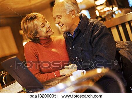 Mature couple sitting together with laptop. View Large Photo Image Stock Image - Mature couple sitting together with laptop.. Fotosearch