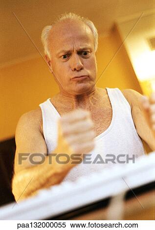 Mature man making fist, looking unhappy, with computer keyboard View Large Photo Image Stock Photography - Mature man making fist, looking unhappy, with computer keyboard. Fotosearch
