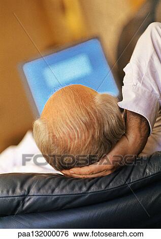 Stock Photograph - Mature man using laptop, rear view.. Fotosearch