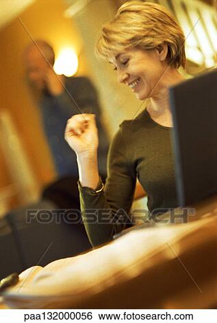 Mature woman smiling, using laptop, head turned, man using cell phone in background View Large Photo Image Stock Photograph - Mature woman smiling, using laptop, head turned, man using cell phone in background. Fotosearch