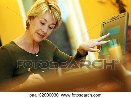 Mature woman using laptop, taking notes. View Large Photo Image Stock Image - Mature woman using laptop, taking notes.. Fotosearch