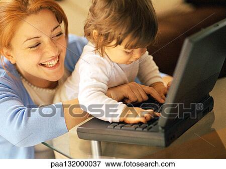 Mother and baby using laptop, portrait. View Large Photo Image Stock Photo - Mother and baby using laptop, portrait.. Fotosearch
