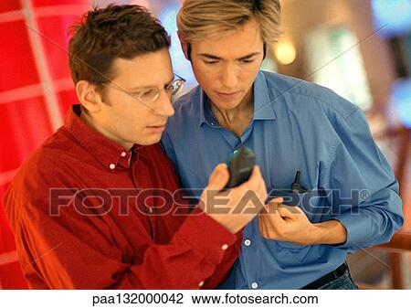Two men using cell phone, portrait. View Large Photo Image Stock Image - Two men using cell phone, portrait.. Fotosearch