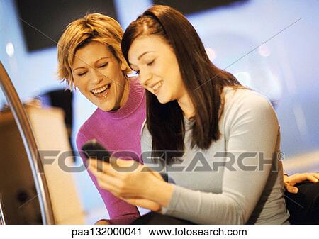 Two women using cell phone, portrait. View Large Photo Image Stock Image - Two women using cell phone, portrait.. Fotosearch