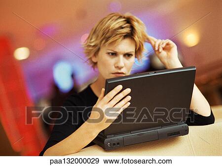 Young woman playing with hair, using laptop, portrait. View Large Photo Image Stock Photo - Young woman playing with hair, using laptop, portrait.. Fotosearch