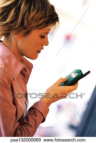 Young woman using cell phone, side view. View Large Photo Image Stock Photo - Young woman using cell phone, side view.. Fotosearch