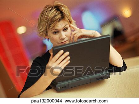 Young woman using laptop, portrait. View Large Photo Image Picture - Young woman using laptop, portrait.. Fotosearch